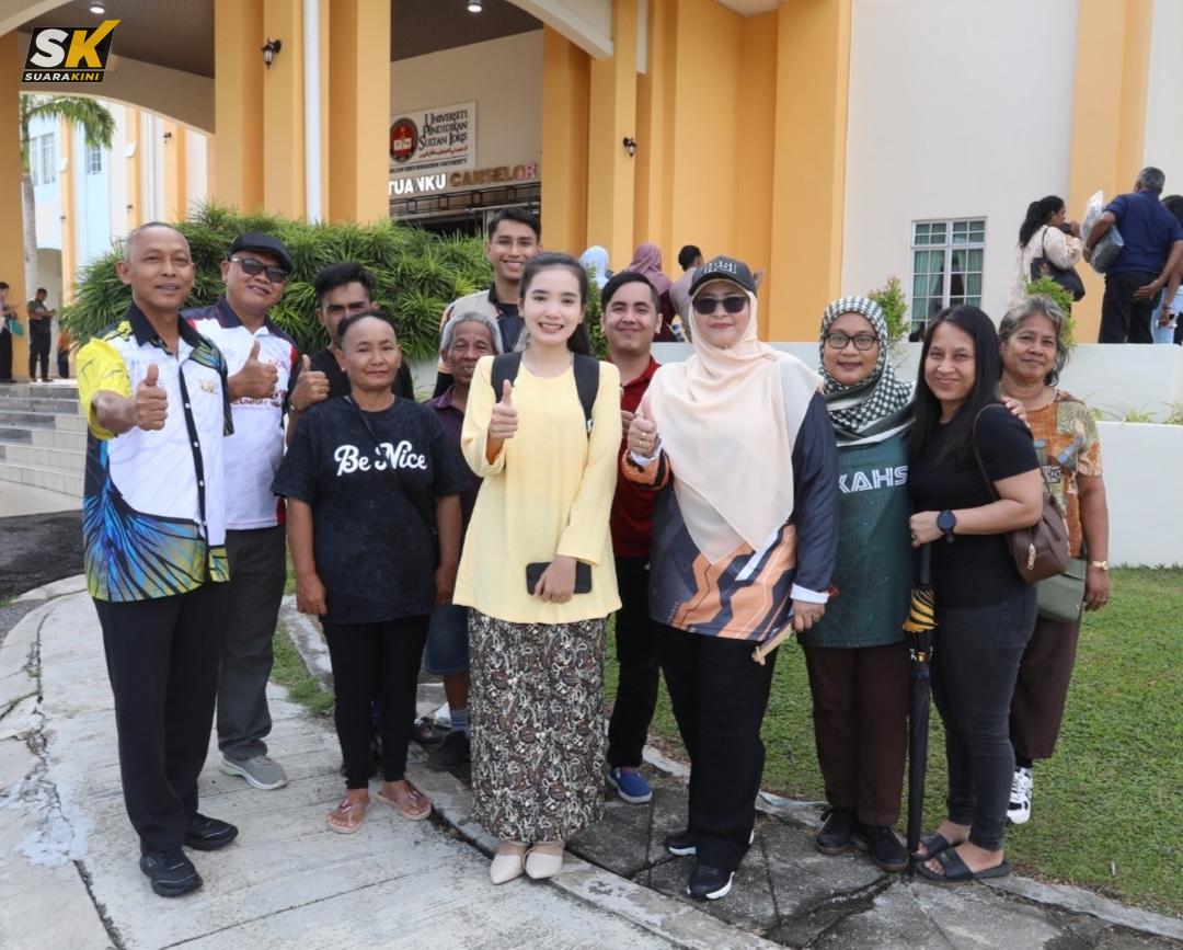 Prof Dr Norkhalid (kiri) menyantuni Lovely Sabana (tengah) dan keluarganya di hadapan Dewan Tuanku Canselor, Kampus Sultan Azlan Shah selepas membuat pendaftaran semalam.